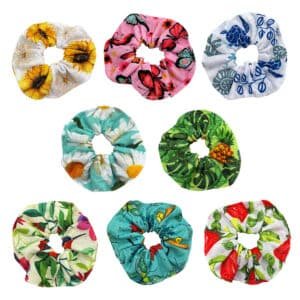 Assorted tropical cotton hair scrunchies featuring floral, butterfly, sea turtle, and botanical prints